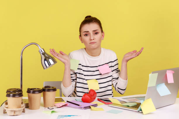 istock Woman covered with sticky notes sitting office workplace with laptop on desk, shrugging shoulders. 2036411736