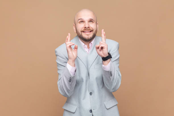 l'uomo incrocia le dita per la fortuna, la speranza per il meglio, il rituale, alza lo sguardo con lo sguardo speranzoso. - fingers crossed liar dishonesty truth foto e immagini stock