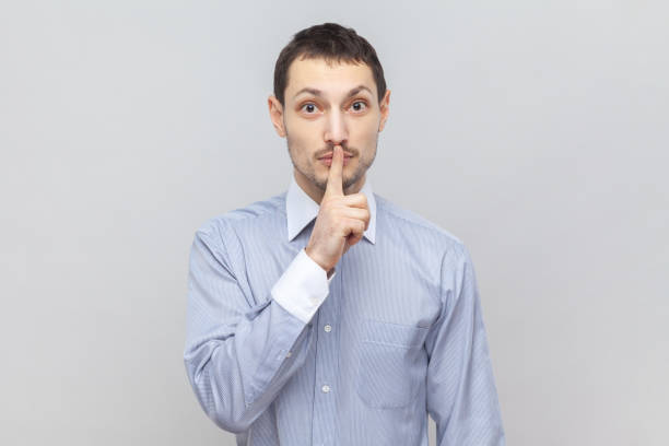 istock Serious man with finger near lips, showing shh gesture, asking to keep silence during lesson. 2036415721