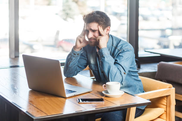istock Tired sick man working on laptop, spending long hours in front of computer screen, massaging temples 2036415740