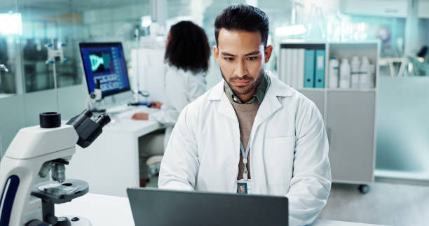 istock Scientist, man and reading computer for laboratory test, typing report or medical results of DNA at night. Asian expert thinking on computer for science research, biotechnology and molecule analysis 2036496610