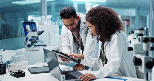 science, teamwork and scientist with tablet in laboratory for communication, pharmaceutical review or planning. employees, collaboration and technology for research, discussion and digital analysis - ilaç stok fotoğraflar ve resimler