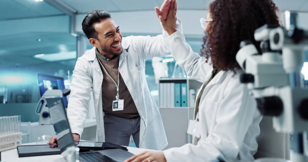istock Scientist, teamwork and high five with laptop in laboratory for test breakthrough, pharmaceutical review or success. Science, collaboration or technology for research, discussion and digital analysis 2036497689