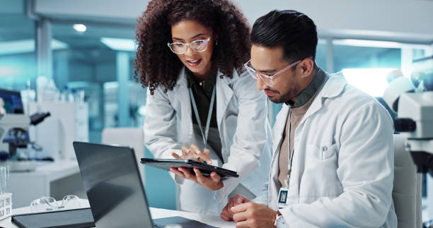 istock Science, teamwork and scientist with tablet in laboratory for communication, pharmaceutical review or planning. Employees, collaboration and technology for research, discussion and digital analysis 2036497698