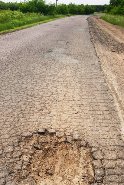 istock Peru road surface damaged with a deep pothole. Ruined street in urgent 2036507596
