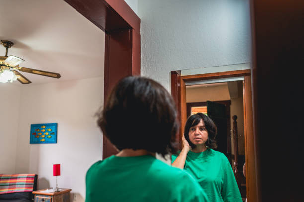 istock Woman looking in the mirror 2036562352