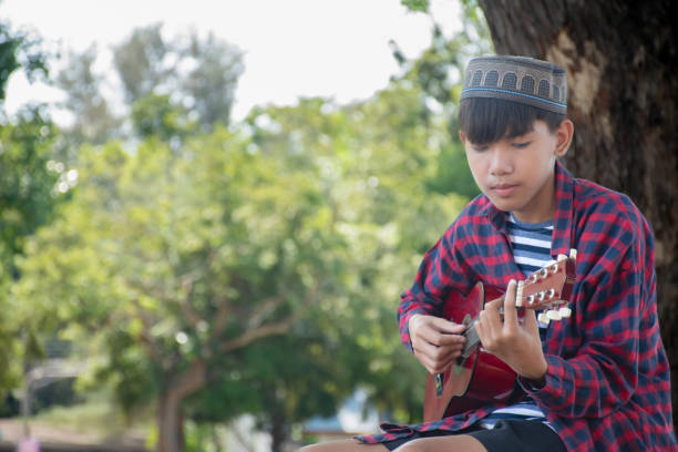 Man, playing guitar, park