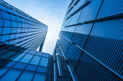 Curves of modern glass shining building on a blue sky background.