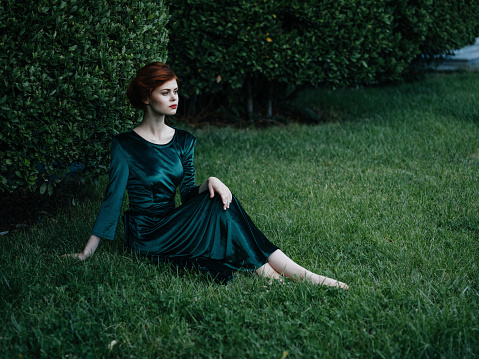 pretty woman in green dress sitting in the garden summer vacation. High quality photo