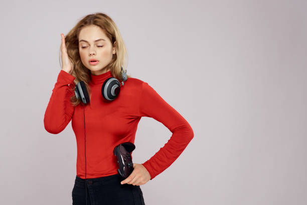 istock Woman with headphones controller in hands a console game fun leisure red jacket lifestyle light background 2036746563