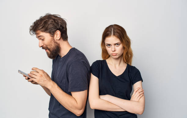 istock cheerful young couple phones in hands studio communication lifestyle 2036788568