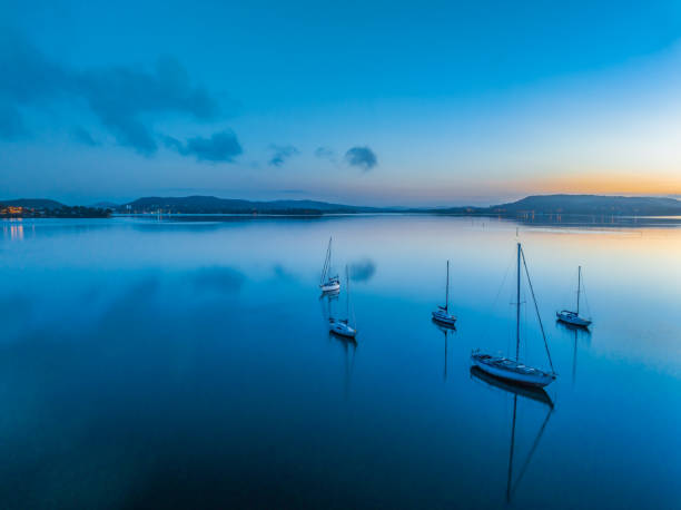 istock Aerial sunrise waterscape with boats, reflections and low cloud 2036791260