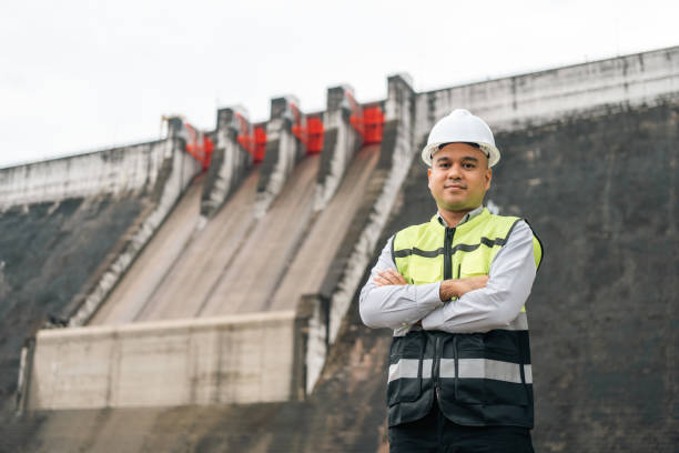 istock Professional asian maintenance engineer man with safety helmet in construction site dam with hydroelectric power plant and irrigation. Manager engineer man working at project big building. 2036804012