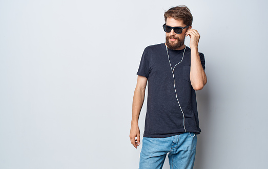 man wearing sunglasses listens to music with headphones elegant style studio lifestyle. High quality photo