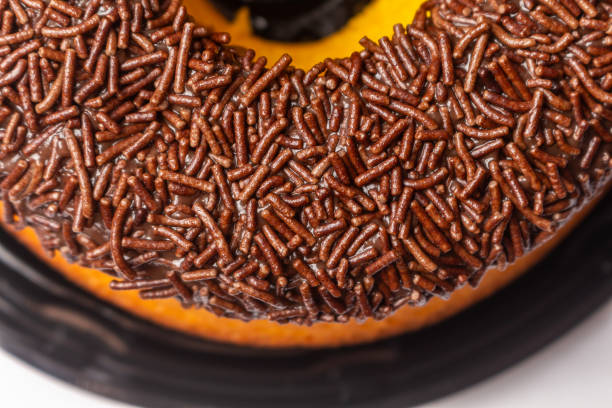 Photograph of a homemade carrot cake with brigadeiro topping and chocolate sprinkles. Traditional Brazilian dessert.