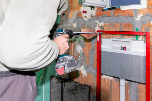 istock A mature  experienced plumber using a screwdriver to  install the frame of a wall-mounted toilet on  brick wall in a construction site. 2036821875