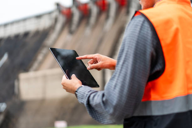 istock Professional asian maintenance engineer man with safety helmet in construction site dam with hydroelectric power plant and irrigation. Manager engineer man working with tablet at project big building. 2036860724