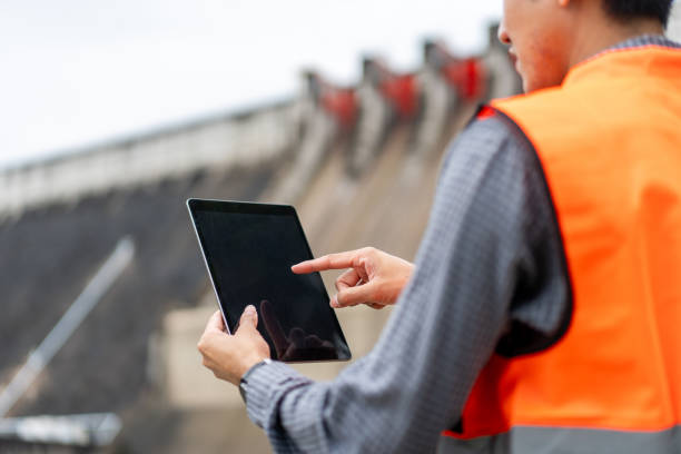 istock Professional asian maintenance engineer man with safety helmet in construction site dam with hydroelectric power plant and irrigation. Manager engineer man working with tablet at project big building. 2036865863