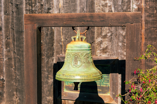Closeup view of a historic green patina bell at Fort Ross, a former Russian settlement in California - California, USA - November 26, 2023