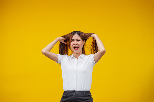 Asian woman  crazy over on  yellow wall background