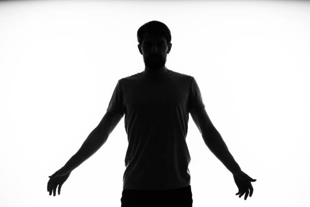 black silhouette of a man who gestures with his hands on a light background. High quality photo
