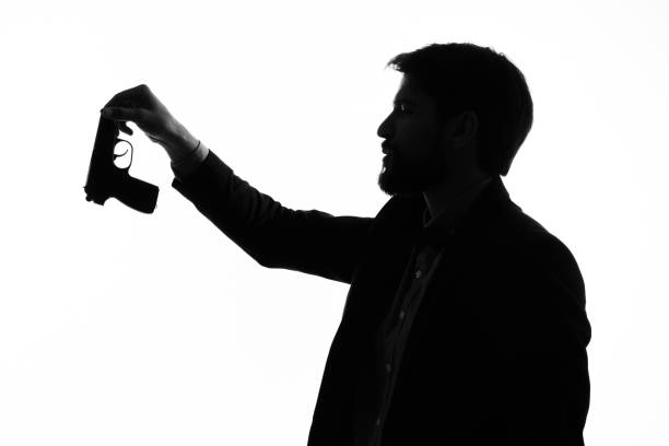 istock shadow of a man with a gun in his hands aiming suicide danger 2036953907