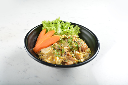 japanese oyakodon chicken rice bowl with salad in black bowl in white marble table asian cafe healthy poke bowl halal vegan menu
