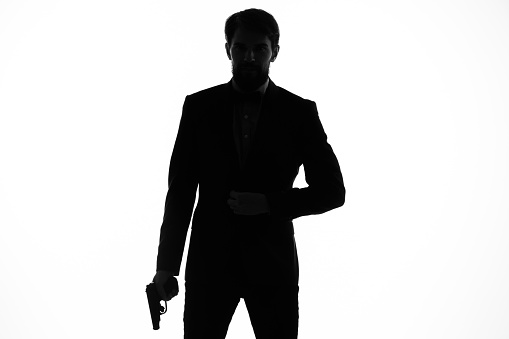 portrait of a man shadow gun in the hands of a detective crime incognito. High quality photo