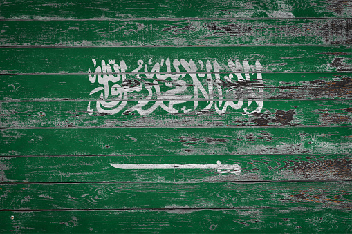 The national flag of  Saudi Arabia  is painted on uneven wooden  boards. Country symbol.