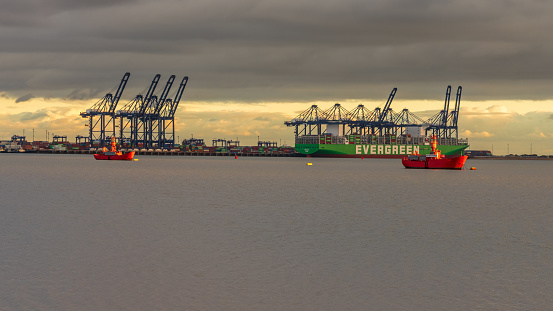 Shotley Gate, Suffolk, England, UK - November 22, 2022: View across the River Orwell to a cargo ship at Felixstowe Harbour
