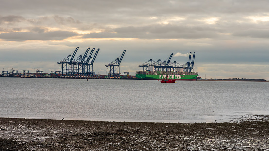 Shotley Gate, Suffolk, England, UK - November 22, 2022: View across the River Orwell to a cargo ship at Felixstowe Harbour