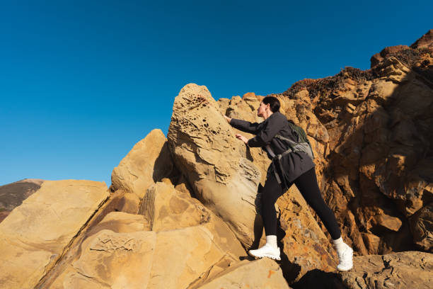 istock Woman climbing on rock during hiking 2037067806