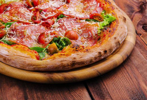 istock Pizza with prosciutto meat, cherry tomatoes, arugula and parmesan cheese 2037136231