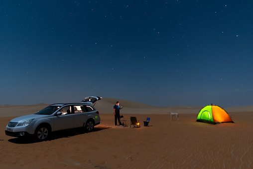 Stars motion across night sky during off road camping in desert.