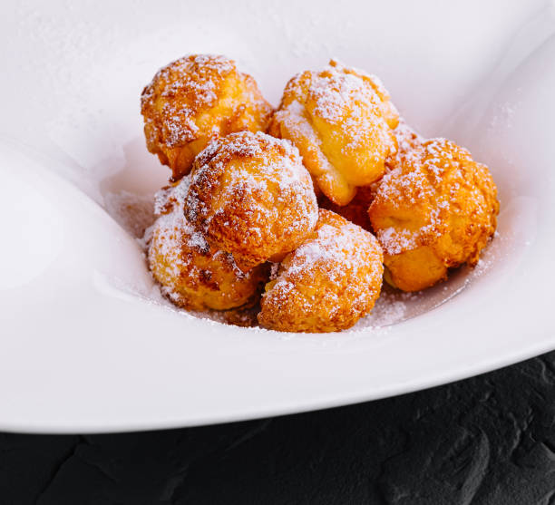 istock Profiteroles with powdered sugar close up 2037175613
