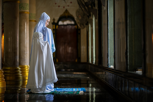 Muslim woman and young Asian Muslim girl praying in the mosque. of Ayutthaya Province, Thailand