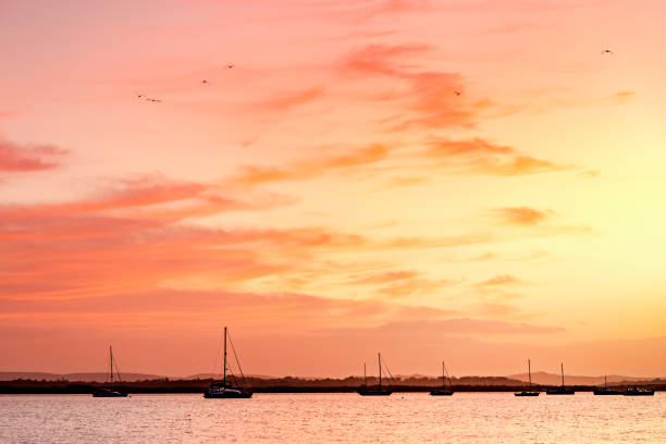 Colourful sunrise over the ocean and yachts at Redland Bay, Queensland, Australia