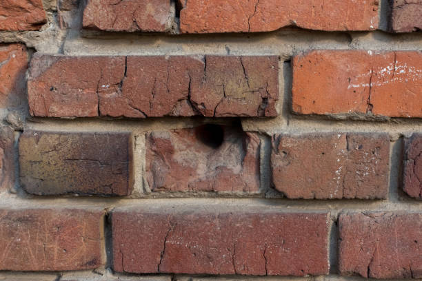 istock Red brick wall with bullet holes 2037260758