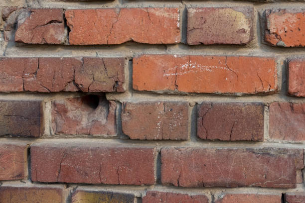 istock Red brick wall with bullet holes 2037260759