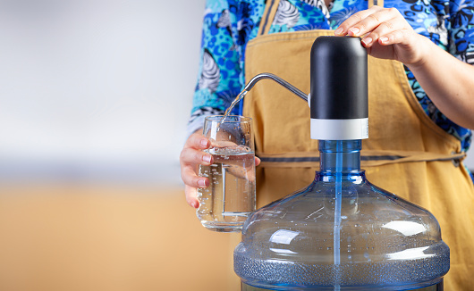 Woman filling water from a water dispenser.