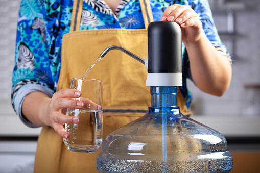 Woman filling water from a water dispenser.