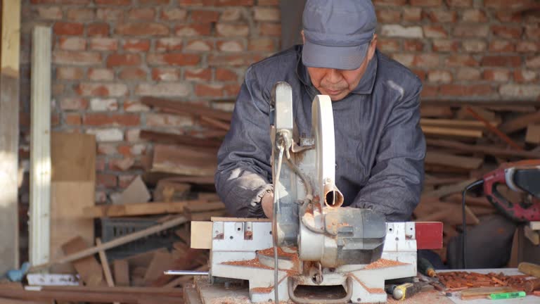 An old carpenter makes wooden handicrafts.