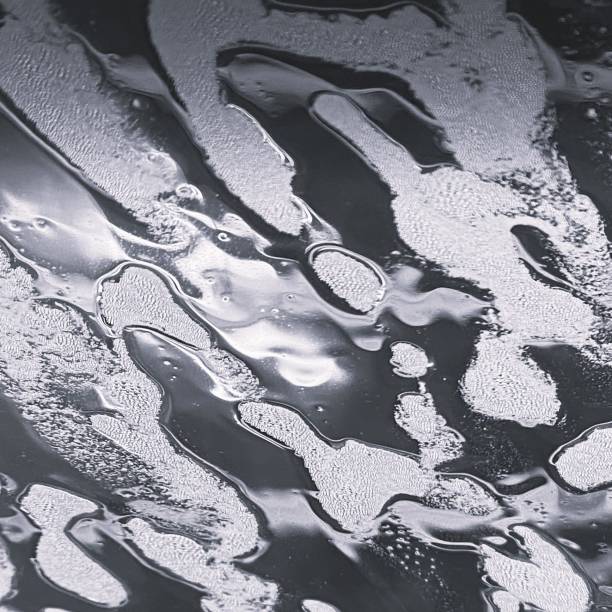 Dynamic chrome shapes flow seamlessly across a dark backdrop, showcasing a mesmerizing interplay of light and shadows, illustrating modern abstract art and creativity.