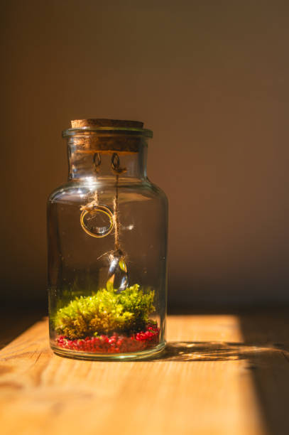 Wedding rings hanging in a glass jar