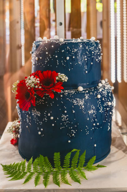 Dark blue wedding cake decorated with pearls and flowers