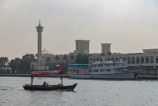 Dubai, United Arab Emirates - November 5, 2023: A picture of an abra boat at the Dubai Creek, in front of a larger ferry.