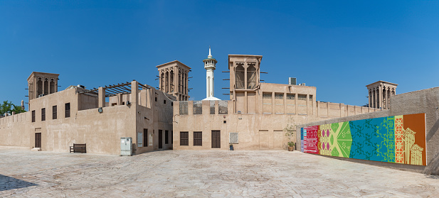 Dubai, United Arab Emirates - November 5, 2023: A picture of the Al Fahidi Historical Neighbourhood, with a colorful mural on the right side.