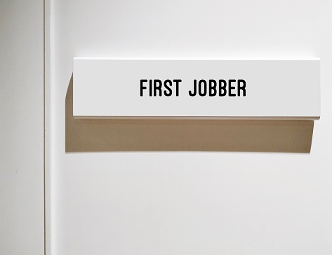 Room with sign FIRST JOBBER - young worker or Gen Z who graduated and in the process of starting career