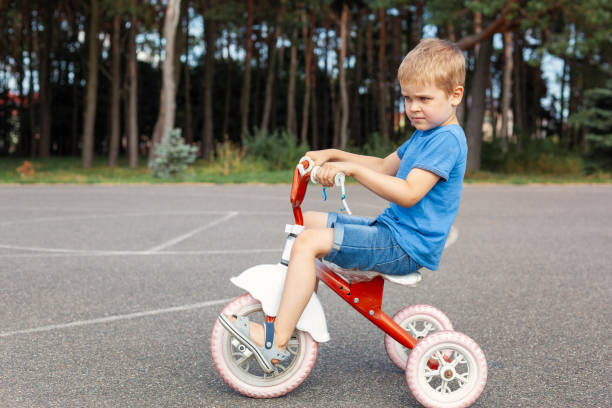 istock Little boy in blue clothes, riding a red old tricycle 2037333693