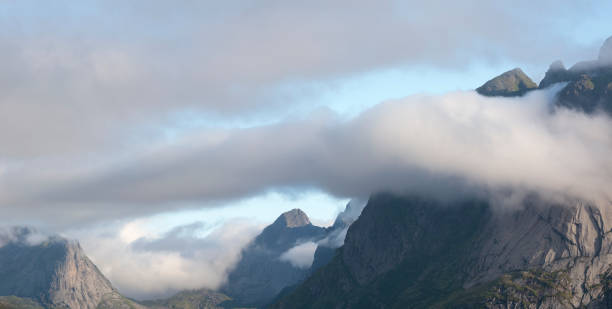 Landscape with mountain peaks in dawn clouds, vacation concept